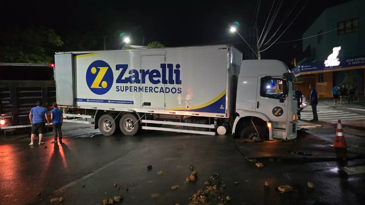 Caminhão afunda no asfalto após rompimento de tubulação