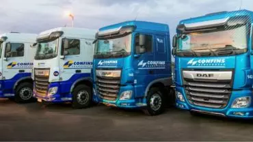 A foto mostra uma frota de caminhões da Confins Transportes