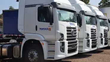 A foto mostra uma frota de caminhões da Tomasi Logística
