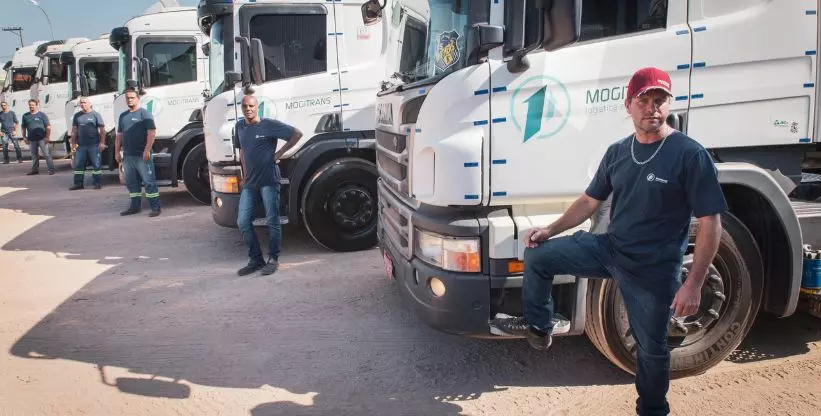 A foto mostra várias carretas da Mogitrans e seus motoristas