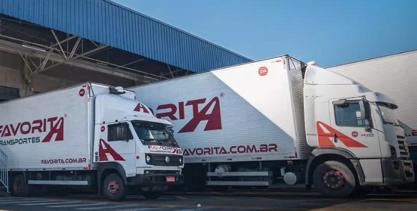 A foto mostra dois caminhões da Favorita Transportes