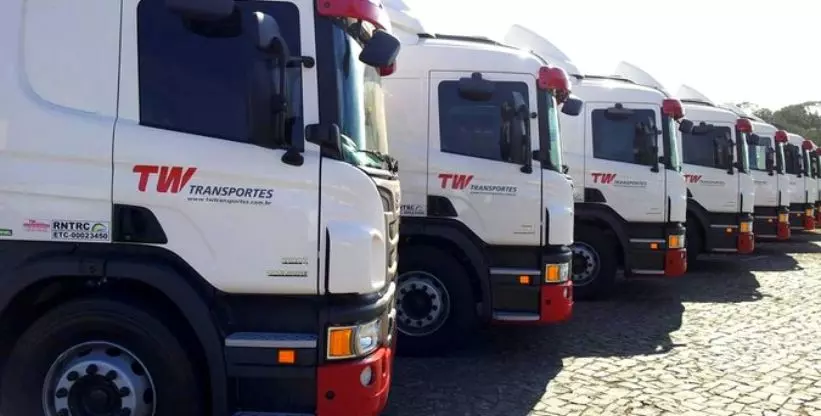 A foto mostra uma frota de caminhões da TW Transportes
