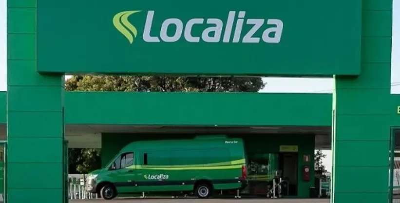 A foto mostra uma Agência da Localiza e uma van