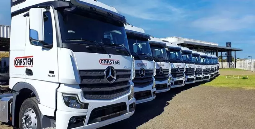 A foto mostra uma frota de caminhões da Carsten