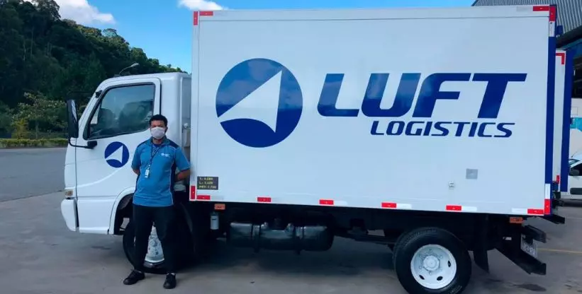 A foto mostra um caminhão e um motorista da Luft Logistics