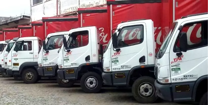 A foto mostra uma frota de caminhões da TFA Logística e Transportes