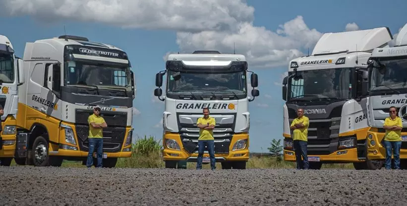 A foto mostra 4 carretas e seus motoristas da Graneleiro Transportes