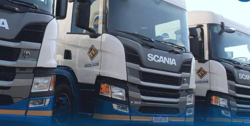 A foto mostra uma frota de caminhões da Transporte Excelsior