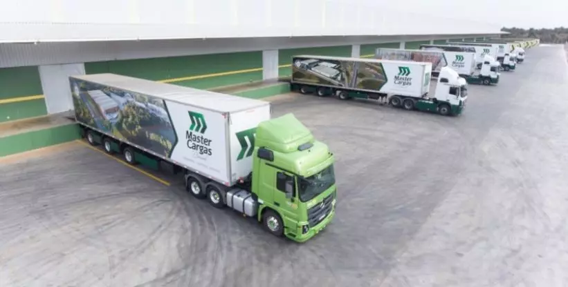 A foto mostra o pátio da Master Cargas com vários caminhões.