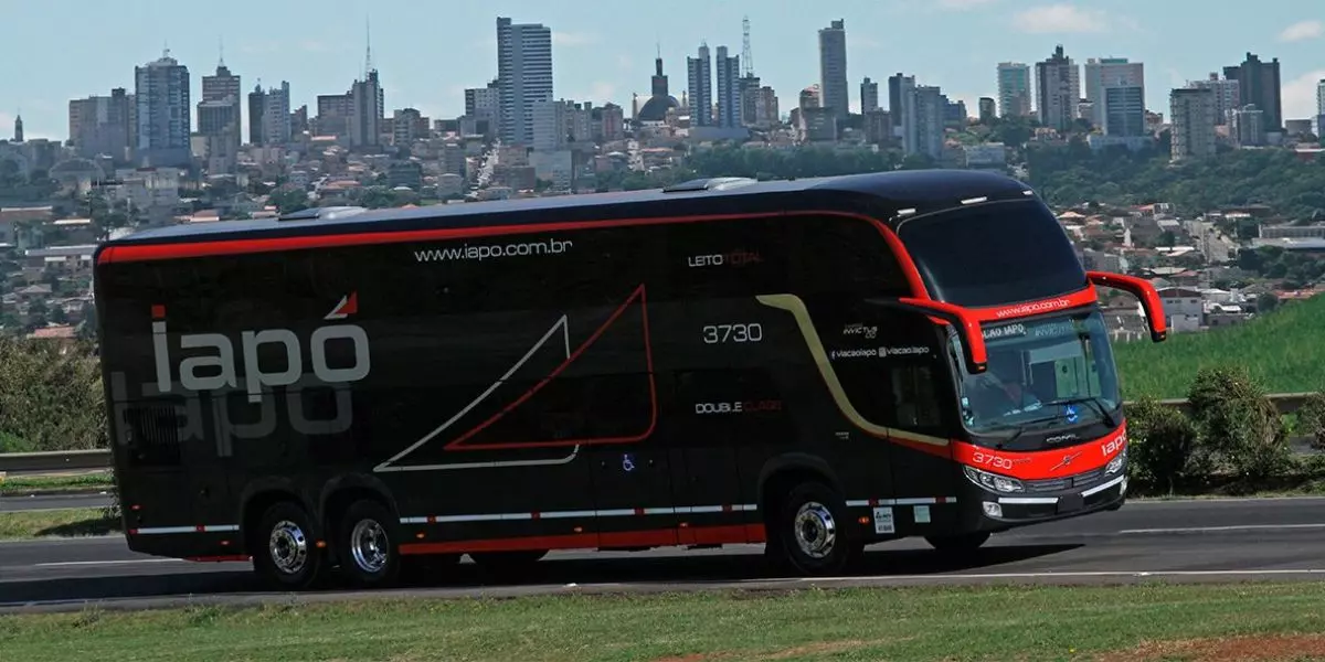 A imagem mostra um ônibus preto da Viação Iapó