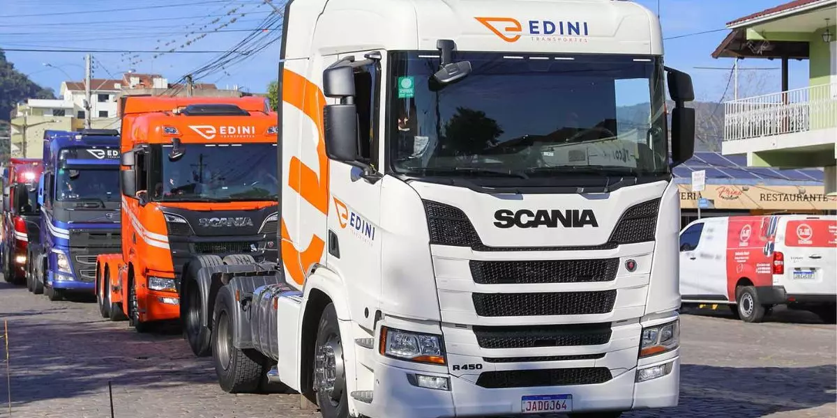 A foto mostra uma frota de caminhões da Edini Transportes