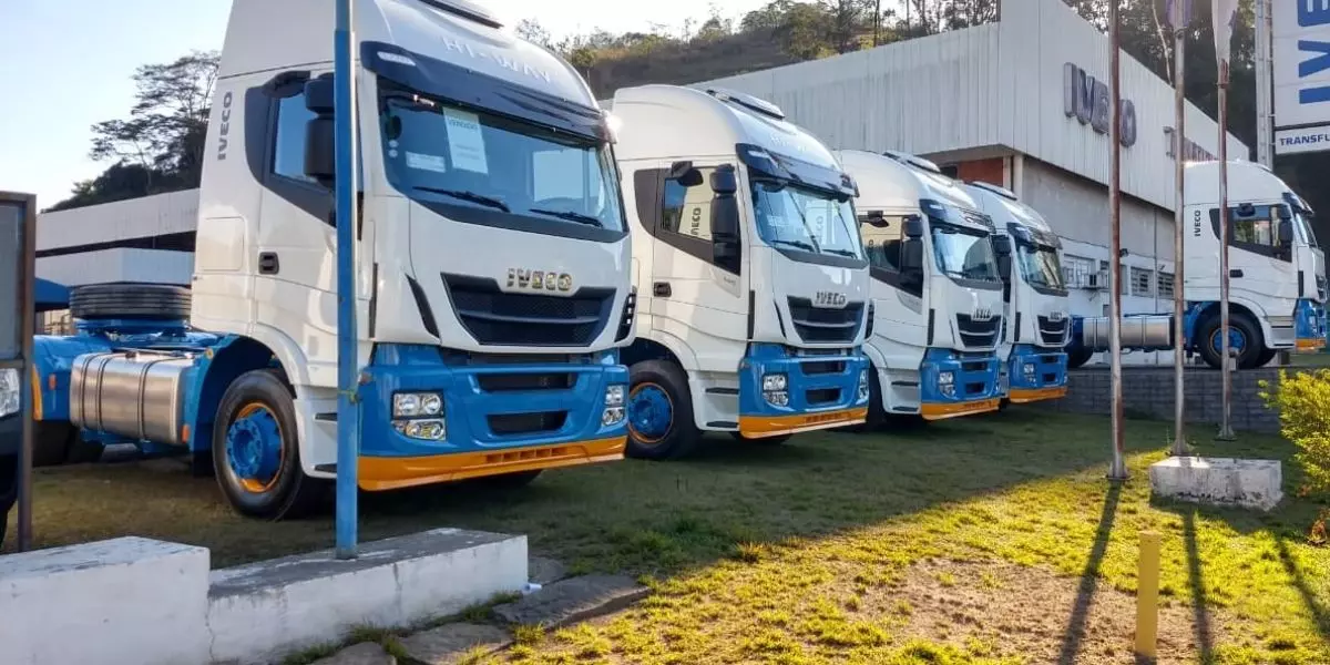 A foto mostra uma frota de caminhão da Transporte Excelsior