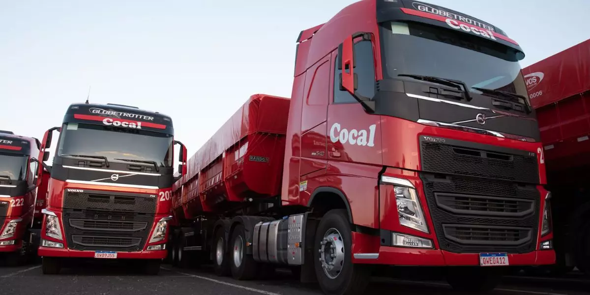 A foto mostra 3 caminhões da empresa Cocal Transportes