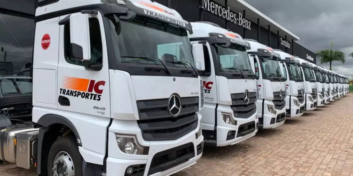 A foto mostra um frota de caminhões da IC Transportes