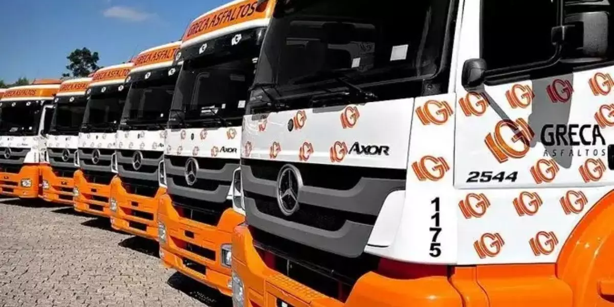 A foto mostra uma frota de caminhão do Grupo Greca Asfalto