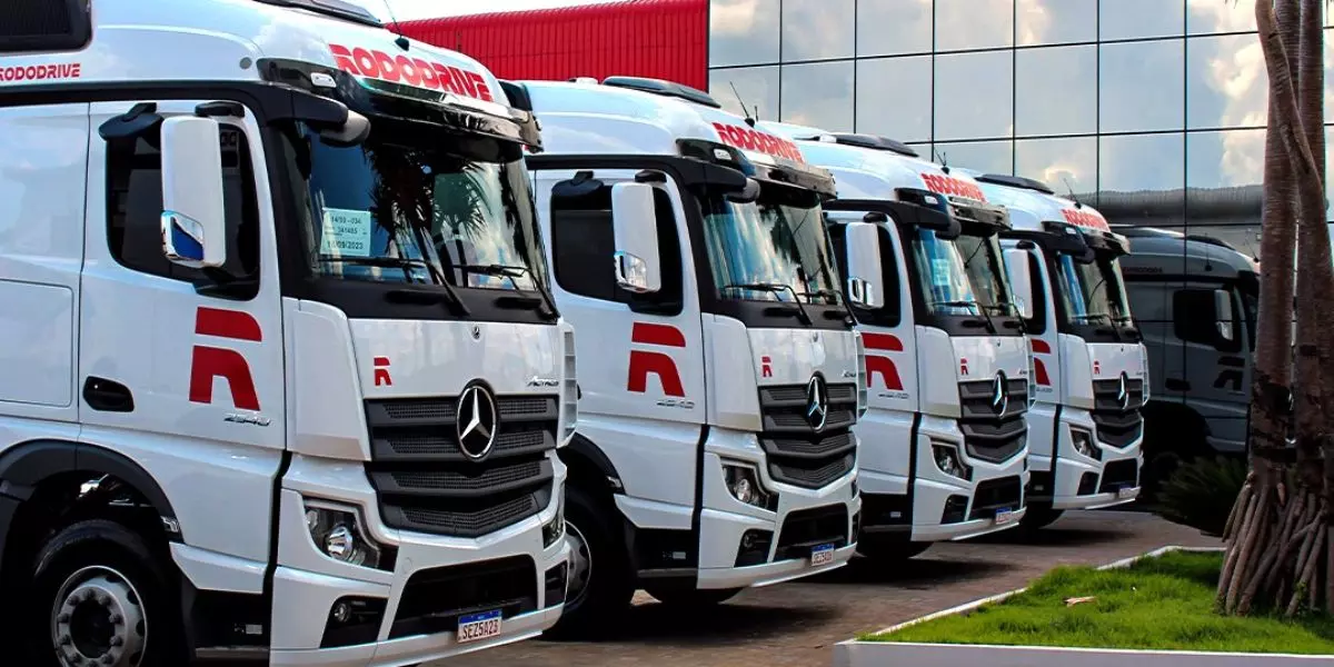 A foto mostra uma frota de carretas da Rodo Drive Transportes