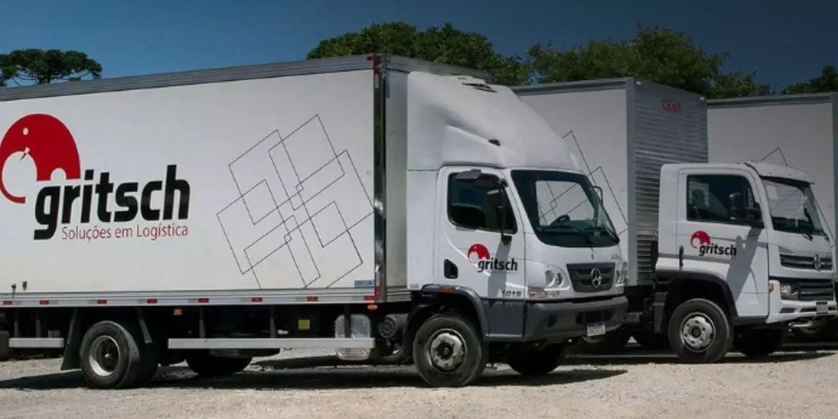 A foto mostra uma frota de caminhões da Gritsch Soluções em Logística