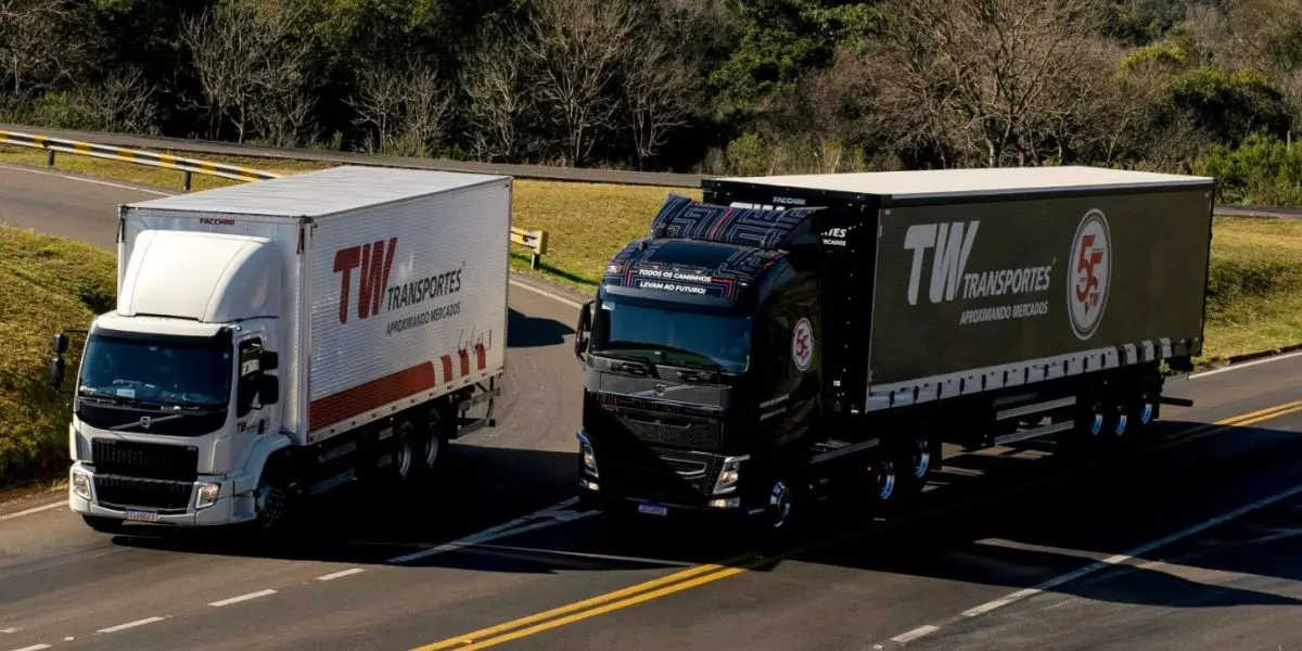 A foto mostra um caminhão Truck e uma carreta da TW Transportes
