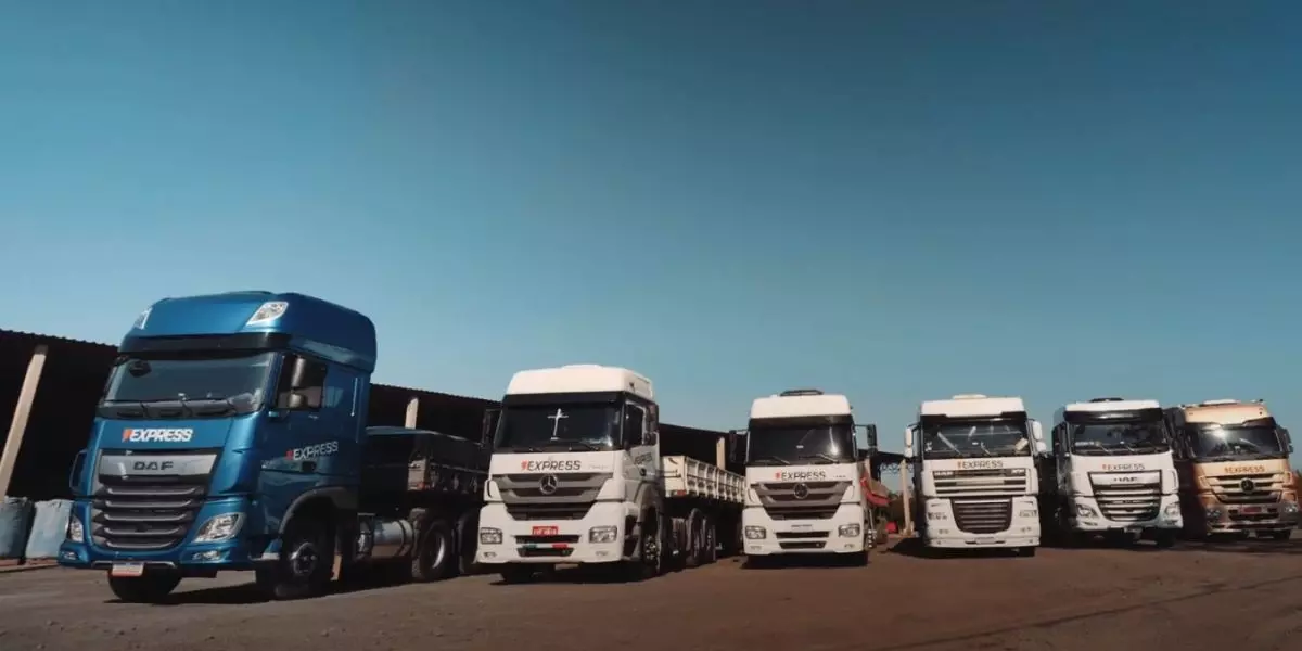 A foto mostra uma frota de carretas da Express Carregamento e Transportes Ltda