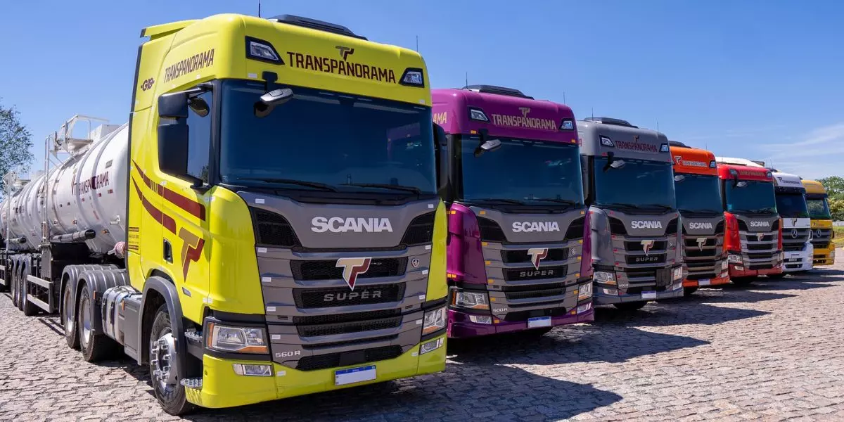 A foto mostra uma frota de carretas da Transpanorama