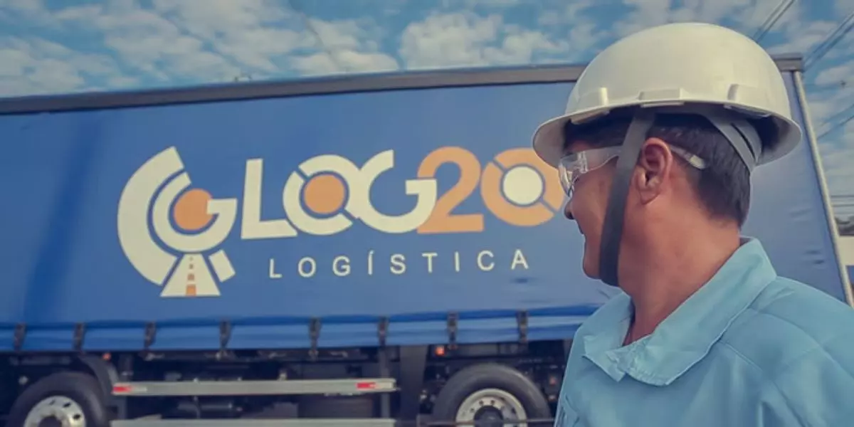 A foto mostra uma carreta e um motorista da LOG20 Logística