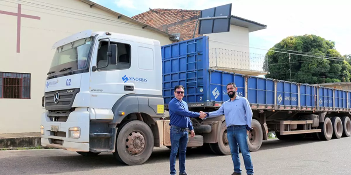A foto mostra uma carreta e dois motoristas da SINOBRAS