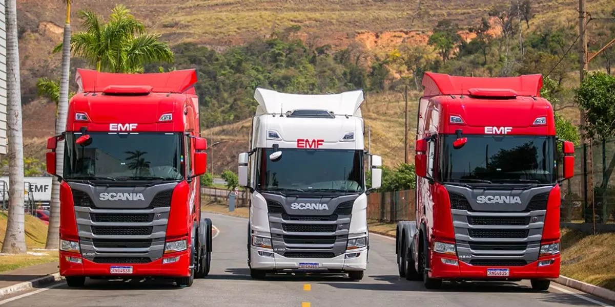 A foto mostra uma frota de caminhões do Grupo EMF Logística