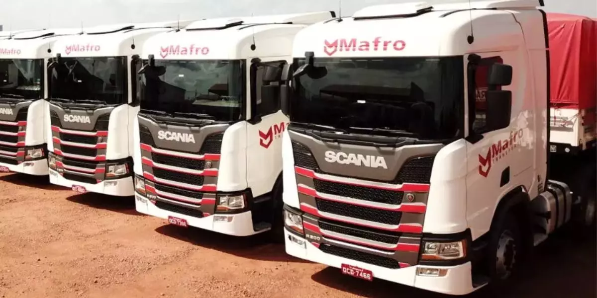 A foto mostra uma frota de caminhões da Mafro Transportes
