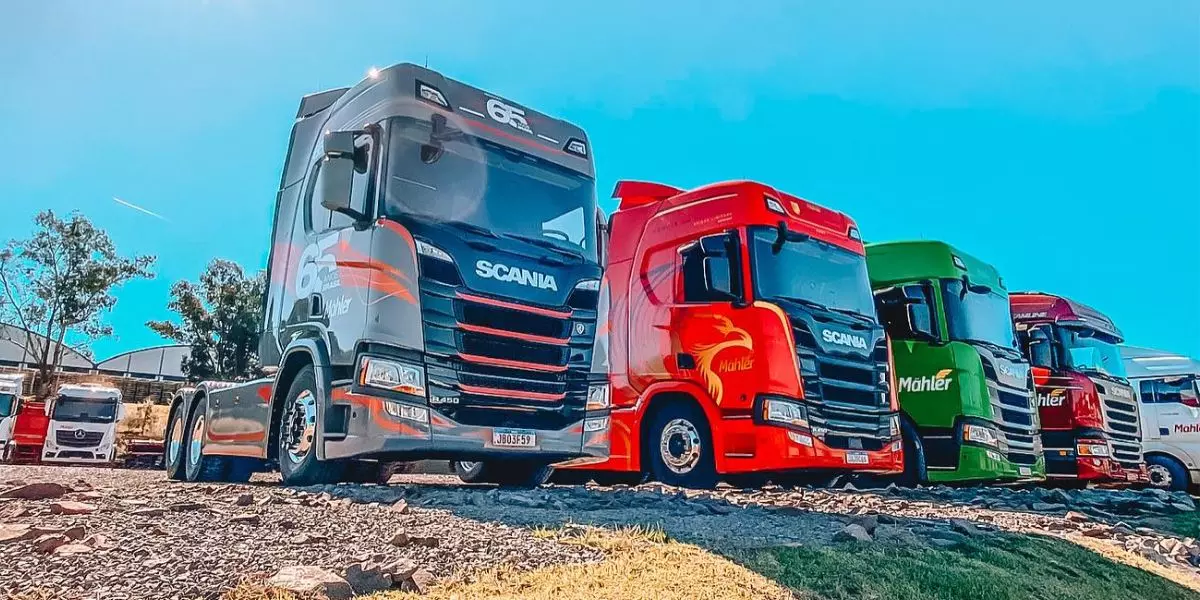A foto mostra uma frota de caminhões da Transportes Mahler
