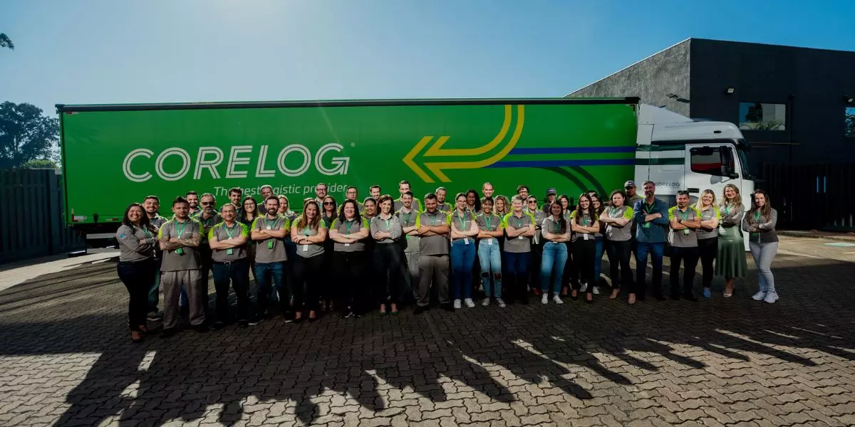 A foto mostra uma carreta e vários funcionários da Corelog