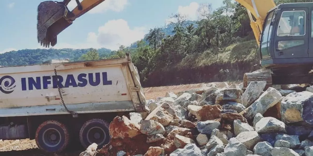 A foto mostra um caminhão basculante da Infrasul