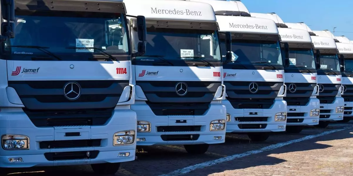A foto mostra uma frota de caminhões da Jamef Transportes