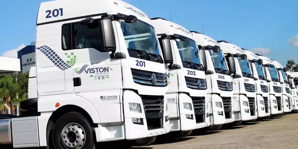 A foto mostra uma frota de caminhões da Viston Logística