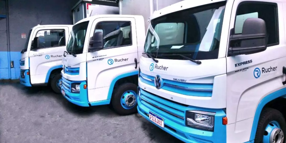 A foto mostra uma frota de caminhões da Rucher Transportes
