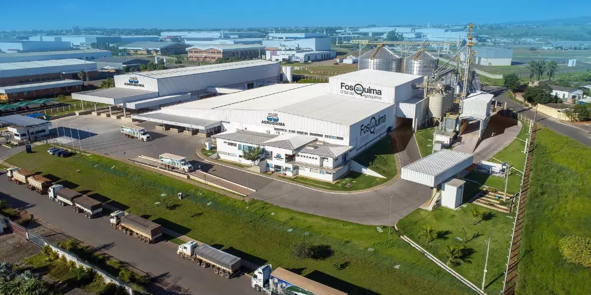 A foto mostra a empresa AGROQUIMA e vários caminhões