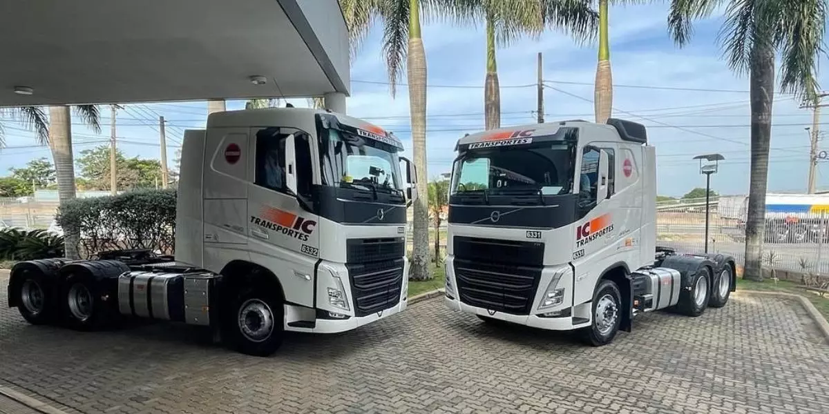 A foto mostra dois caminhões da IC Transportes