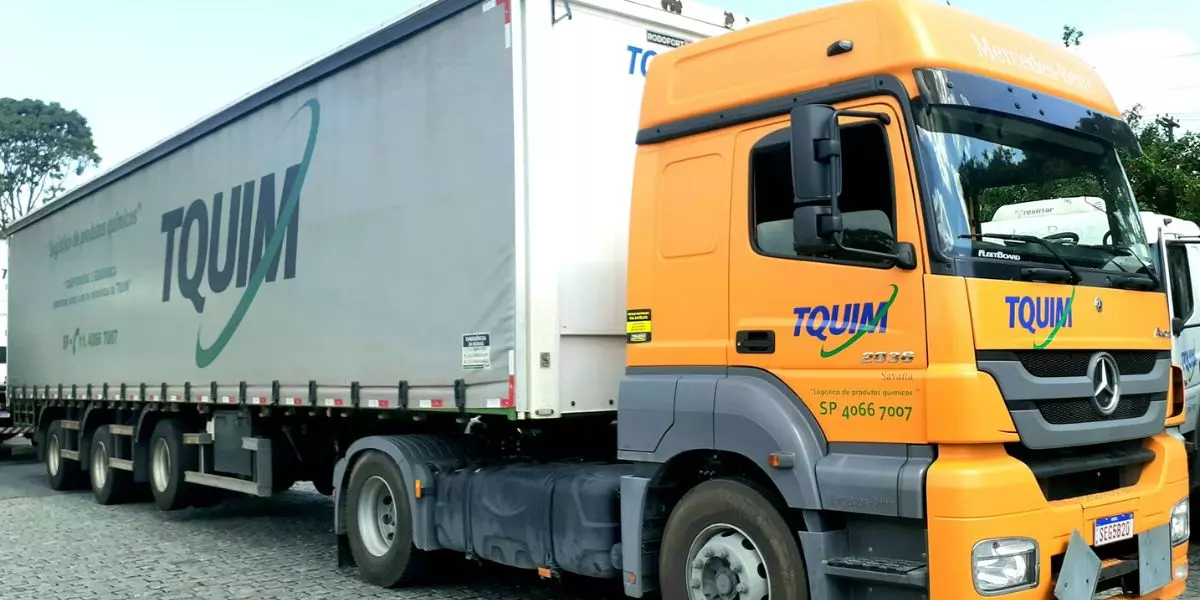 A foto mostra uma carreta da TQUIM Transportes