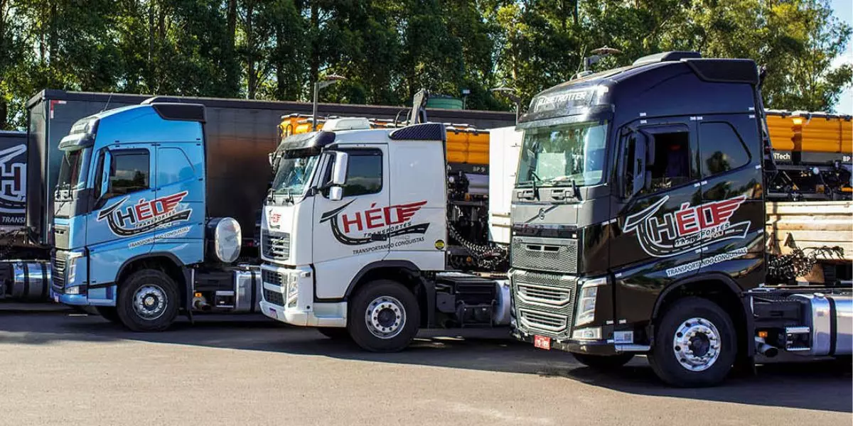 A foto mostra uma frota de carretas da Théo Transportes