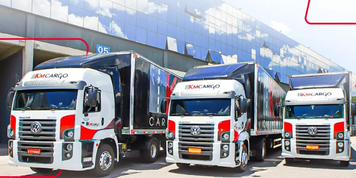 A foto mostra uma frota de caminhões da KM Cargo