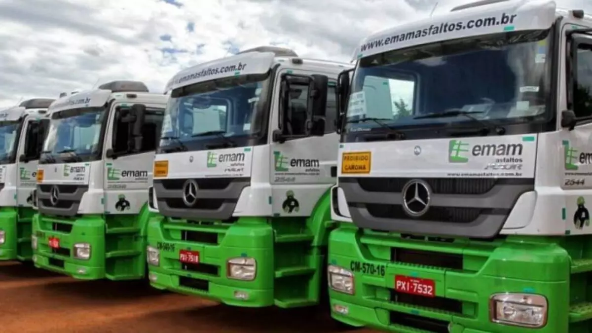 A foto mostra uma frota de carretas da Emam Asfaltos
