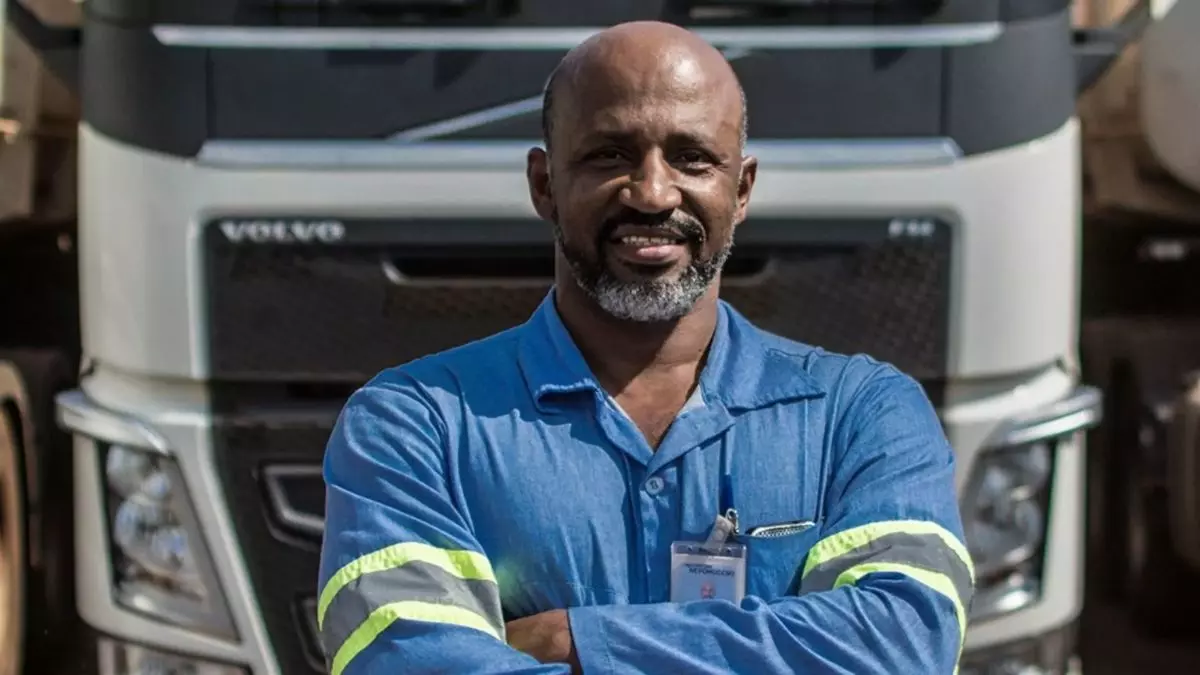 A foto mostra um motorista e uma carreta da Expresso Nepomuceno