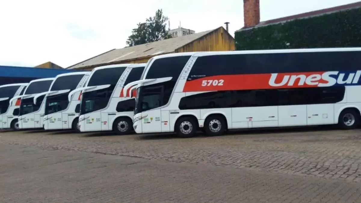 A foto mostra uma frota de ônibus da UneSul