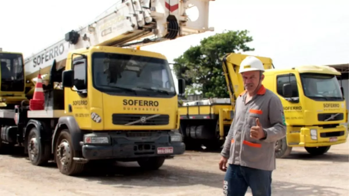 A foto mostra dois caminhões e um motorista da Soferro