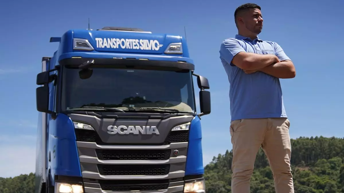 A foto mostra uma carreta e um motorista da Transportes Silvio