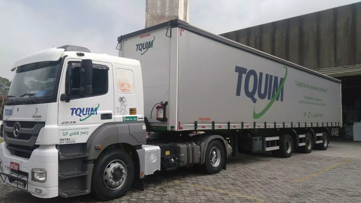 A foto mostra uma carreta da TQUIM Transportes