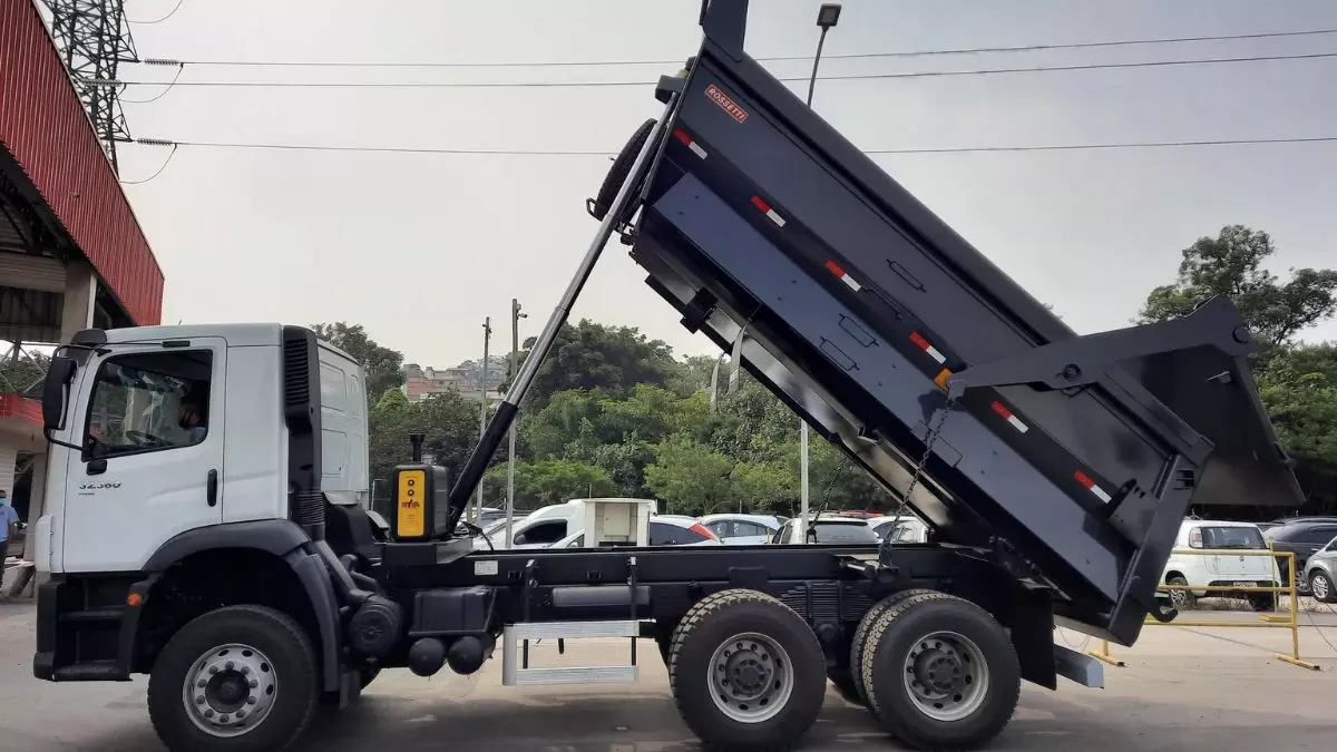A foto mostra um caminhão basculante da Retec Caçambas