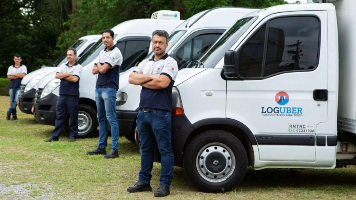 A foto mostra uma frota de veículos e motoristas da LogUber