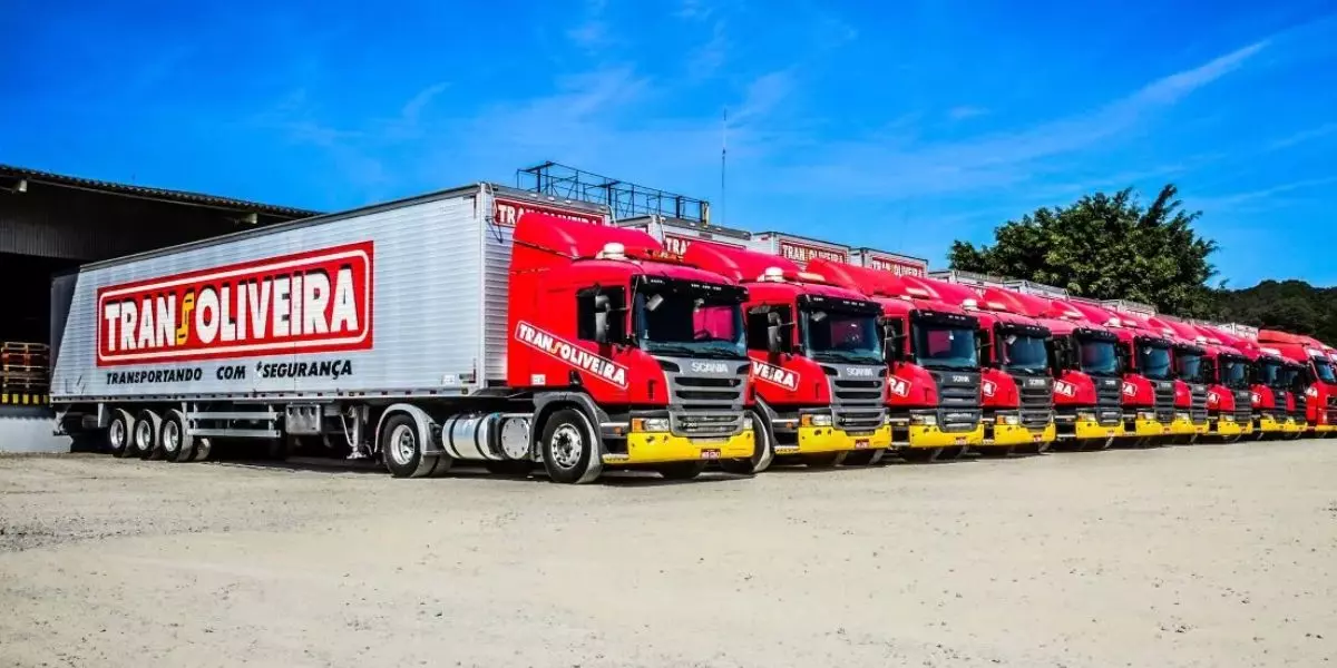 A foto mostra uma frota de carretas da Transoliveira