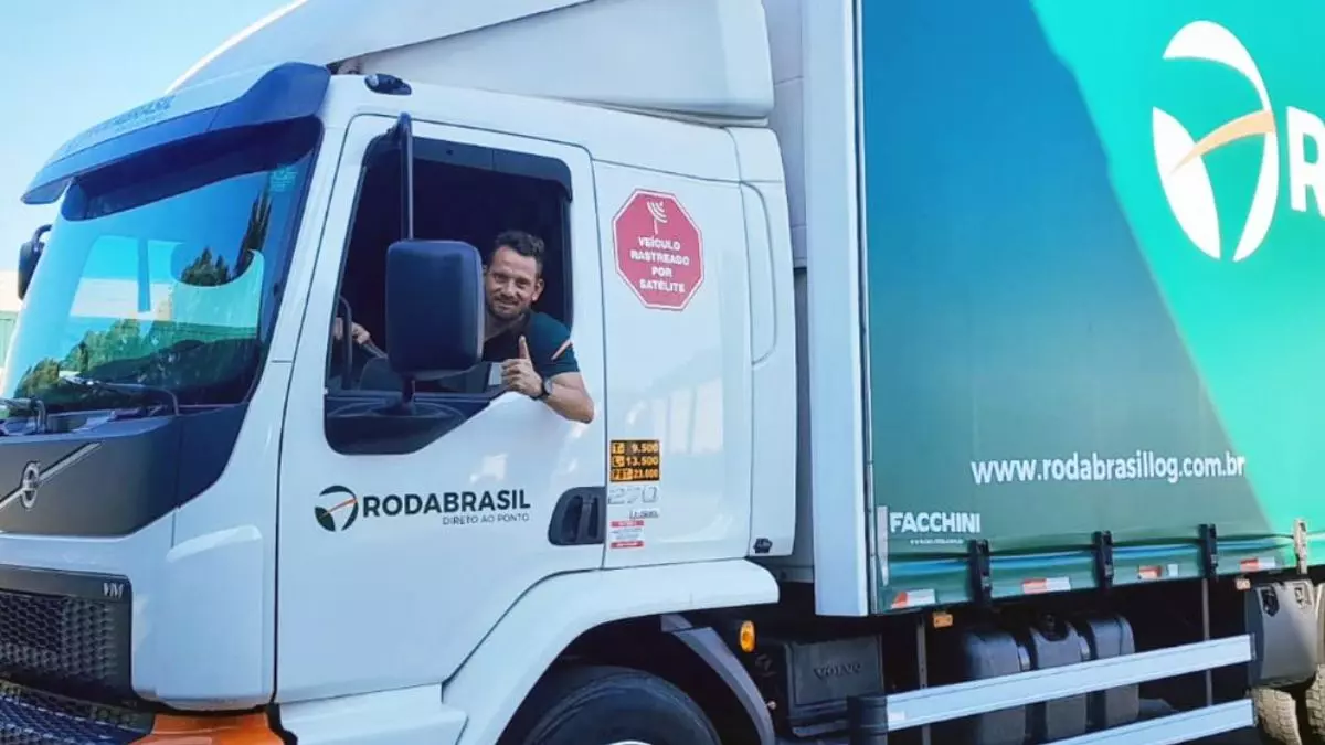 A foto mostra um caminhão e 1 motorista da Roda Brasil Logística
