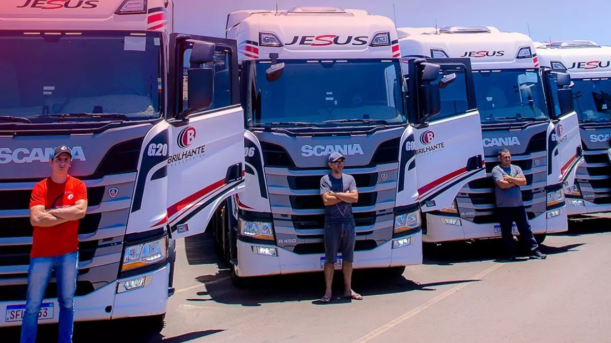 A foto mostra frota de caminhões da Brilhante Transportes e seus motoristas